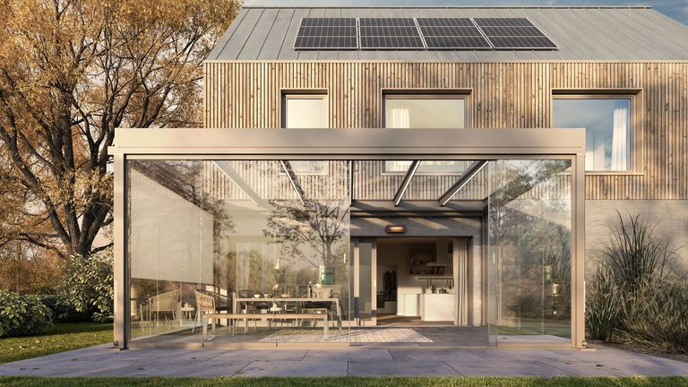 Eine moderne Überdachung mit Glasdach über einer Terrassensituation in einem grünen Umfeld.