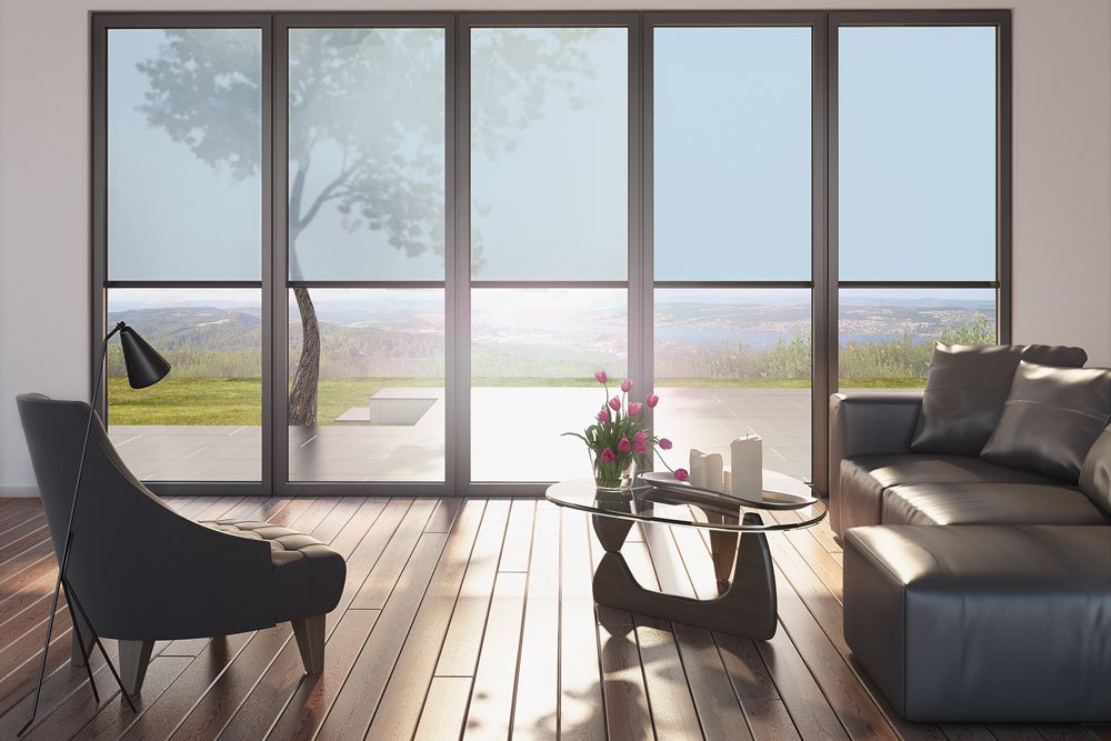 Moderner Wohnraum mit Fenstern, Blick auf die Landschaft, Holzfußboden und stilvollen Möbeln.