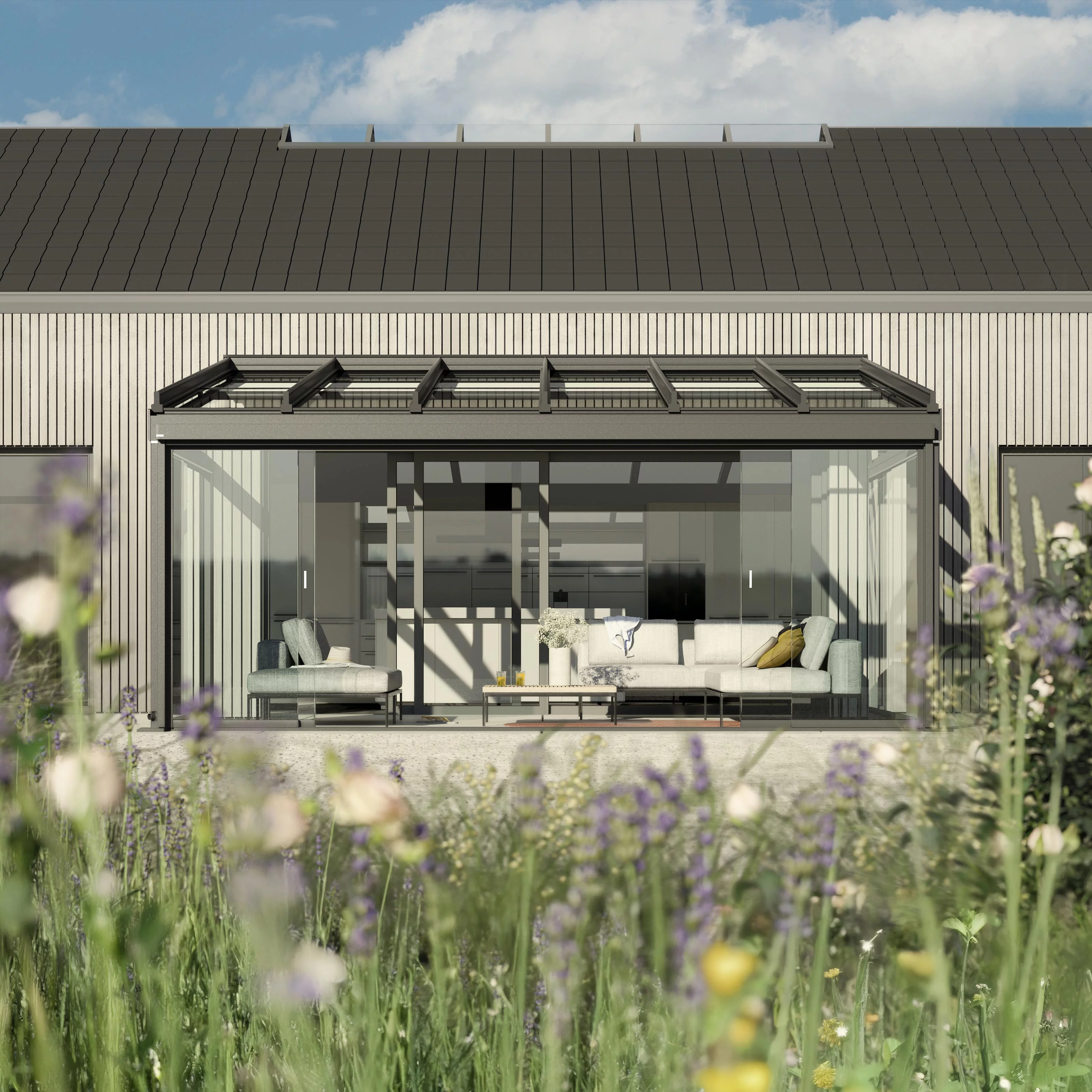 Moderne Hausfassade mit Glas-Schiebewänden und einer Überdachung, umgeben von bunten Blumen.