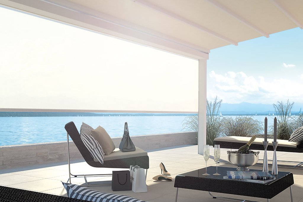 Terrassensituation mit Überdachung, Blick aufs Wasser und verschiedene Sitzmöglichkeiten in neutralen Farben.