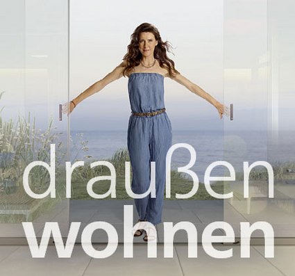 Bild einer Frau, die vor einer Glasfront steht, mit dem Text "draußen wohnen" im Vordergrund.
