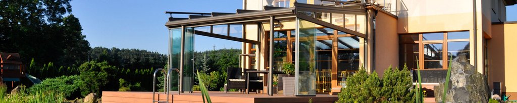Moderne Überdachung mit Glas und Holz, umgeben von Pflanzen und einer Terrassensituation. Moderne Überdachung mit Glas und Holz, umgeben von Pflanzen und einer Terrassensituation.