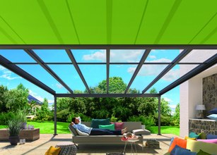 Blick auf eine Überdachung mit grünem Markisentuch und einer Terrassensituation im Freien. 