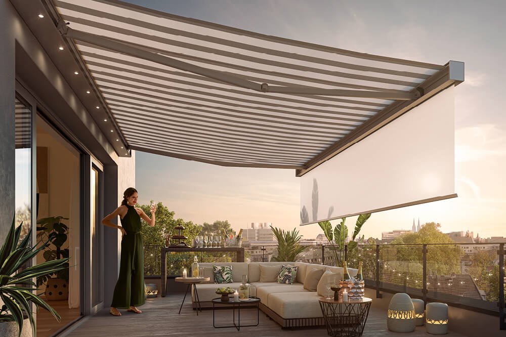 Eine großzügige Markise mit gestreiftem Design über einer modernen Terrassensituation im Abendlicht.