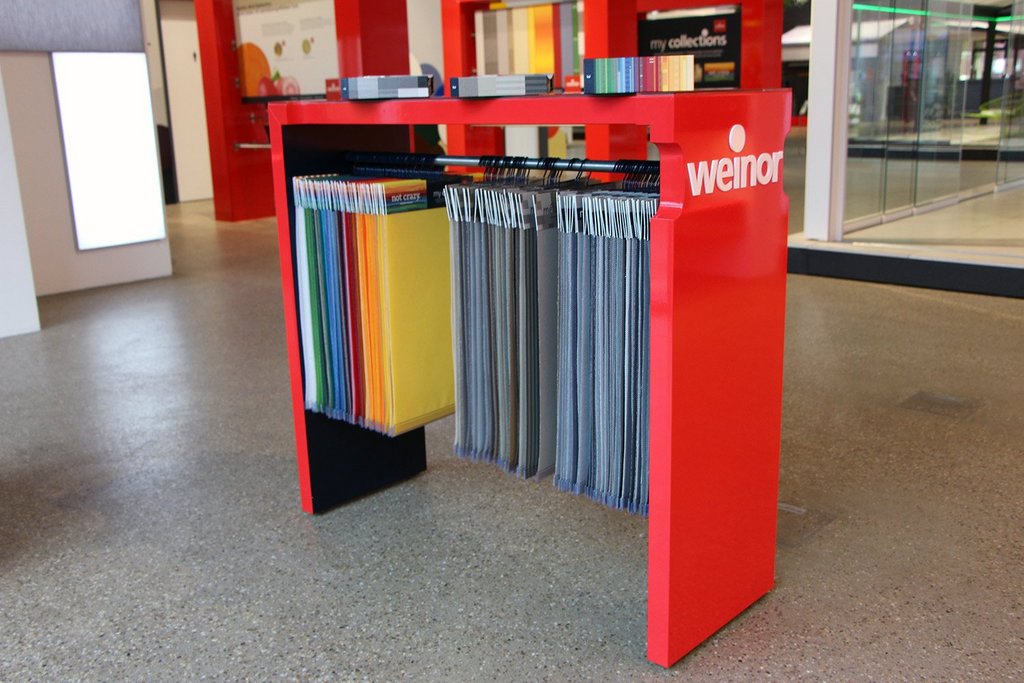 Ein roter Tisch mit bunten Stoffmustern hängt an der Seite. Ein roter Tisch mit bunten Stoffmustern hängt an der Seite.